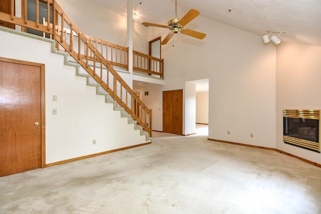52 Ridgewood Dr Unit 14C, Atkinson, NH 03811 - unfurnished living room with high vaulted ceiling, carpet, stairway, baseboards, and ceiling fan