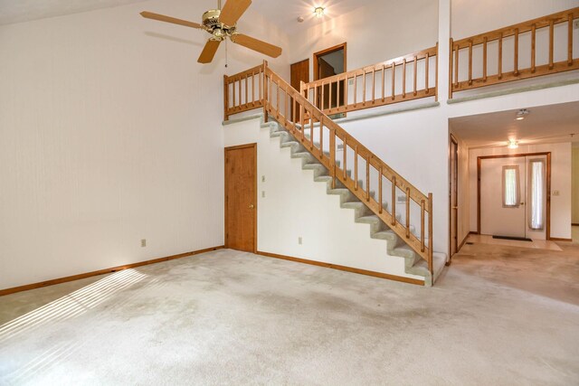 52 Ridgewood Dr Unit 14C, Atkinson, NH 03811 - unfurnished living room with a towering ceiling, carpet floors, stairway, and baseboards