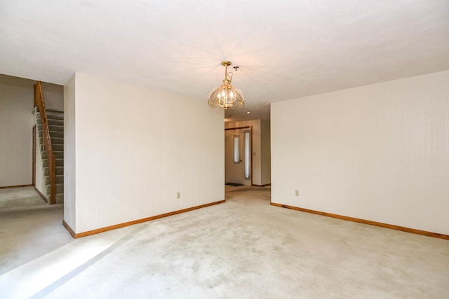 52 Ridgewood Dr Unit 14C, Atkinson, NH 03811 - spare room with light carpet, baseboards, a chandelier, and stairway