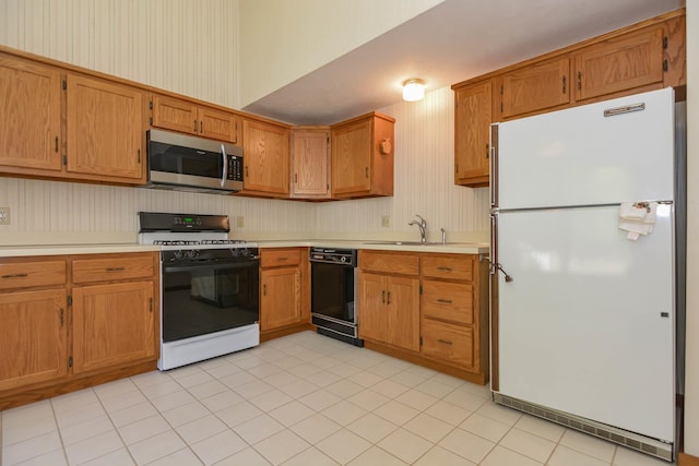 52 Ridgewood Dr Unit 14C, Atkinson, NH 03811 - kitchen featuring freestanding refrigerator, stainless steel microwave, gas stove, black dishwasher, and a sink