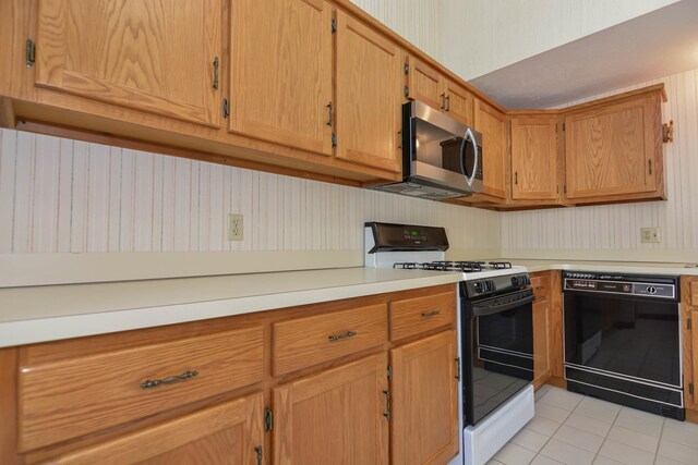 52 Ridgewood Dr Unit 14C, Atkinson, NH 03811 - kitchen featuring gas range, dishwasher, stainless steel microwave, light tile patterned floors, and light countertops