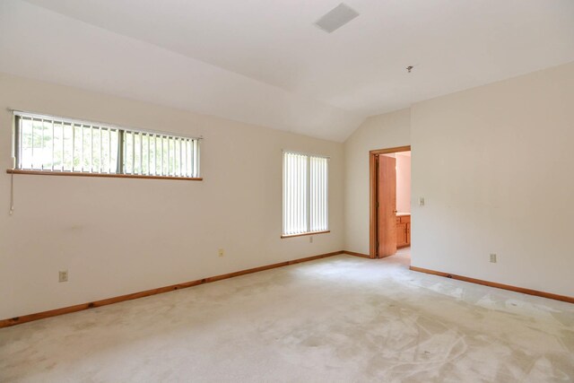 52 Ridgewood Dr Unit 14C, Atkinson, NH 03811 - spare room with baseboards, vaulted ceiling, and light carpet