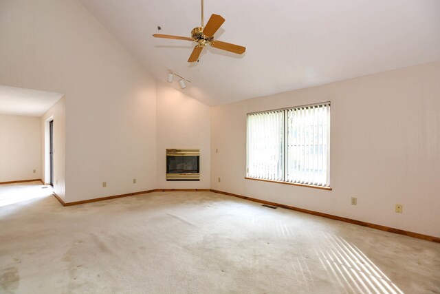 52 Ridgewood Dr Unit 14C, Atkinson, NH 03811 - unfurnished living room featuring light carpet, a glass covered fireplace, baseboards, rail lighting, and high vaulted ceiling