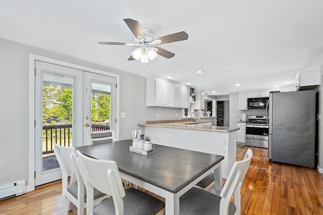 dining room with a baseboard heating unit, light wood finished floors, recessed lighting, ceiling fan, and french doors