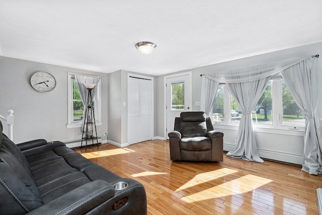 living room featuring a baseboard radiator, hardwood / wood-style floors, and baseboards
