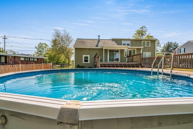 view of swimming pool featuring a deck and fence