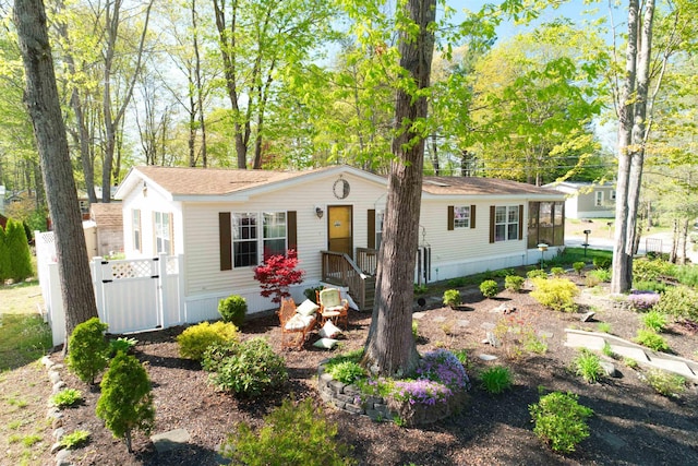 manufactured / mobile home featuring a gate and a shingled roof