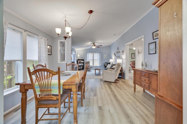 dining room featuring a chandelier, light wood-style flooring, a ceiling fan, crown molding, and baseboards