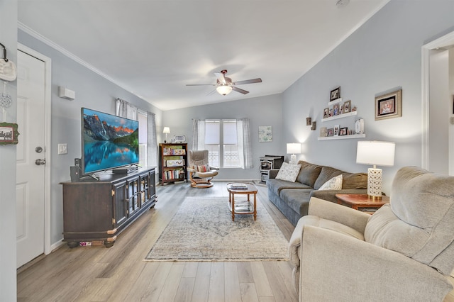 living area featuring a ceiling fan, wood finished floors, ornamental molding, and baseboards