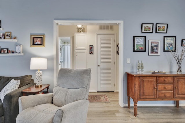 living area featuring light wood-style floors and baseboards