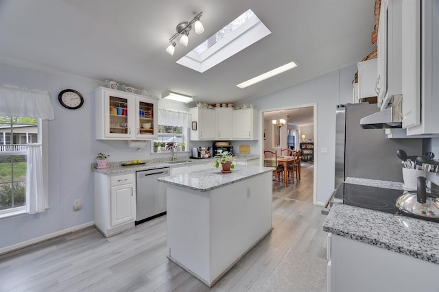 kitchen featuring dishwasher, white cabinets, a sink, lofted ceiling, and crown molding