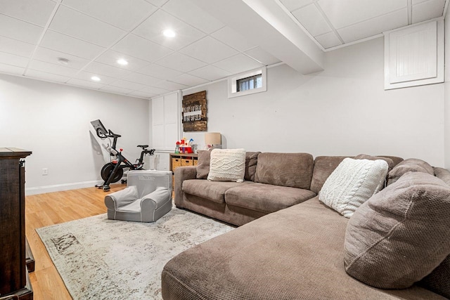 living room featuring wood finished floors, recessed lighting, a paneled ceiling, and baseboards