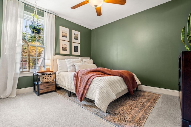 bedroom featuring carpet, baseboards, multiple windows, and a ceiling fan
