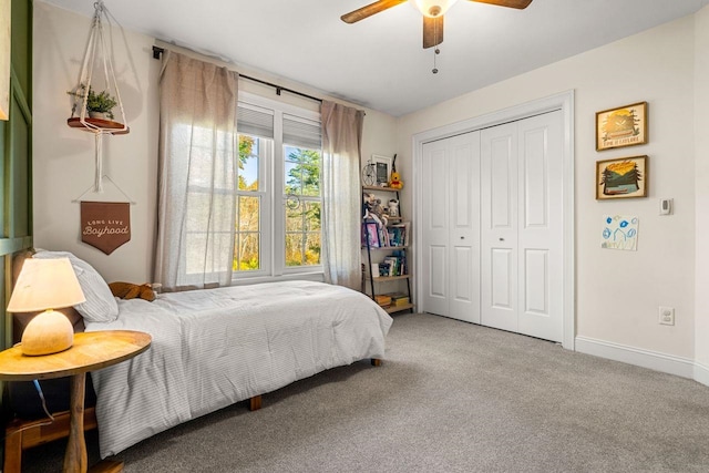 bedroom with a closet, carpet floors, baseboards, and ceiling fan