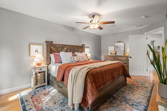 bedroom featuring light wood-type flooring, baseboards, and ceiling fan