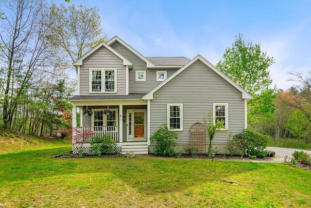 view of front of property featuring a porch, a front lawn, and roof with shingles