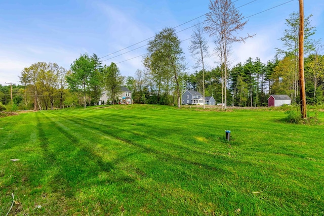 view of grassy yard featuring a storage unit and an outdoor structure
