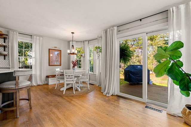 dining space featuring light wood finished floors and a chandelier
