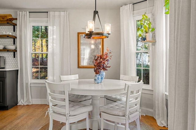 dining space with plenty of natural light, light wood-style floors, and baseboards