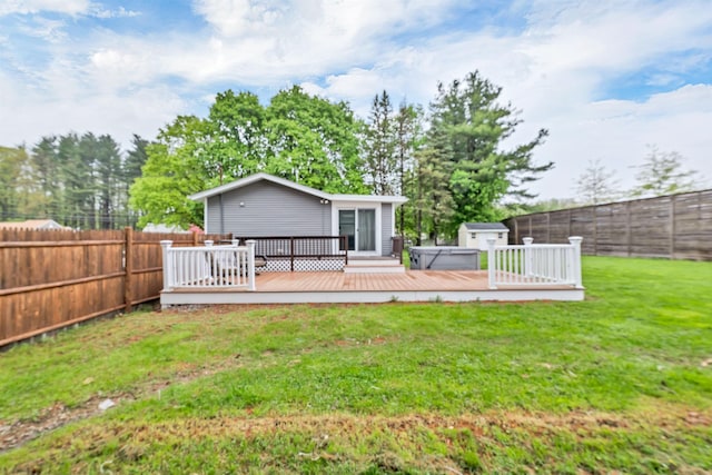 rear view of house featuring a hot tub and a wooden deck