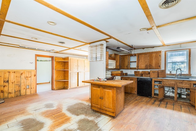 kitchen featuring white appliances, light wood-style floors, a sink, brown cabinets, and a wainscoted wall