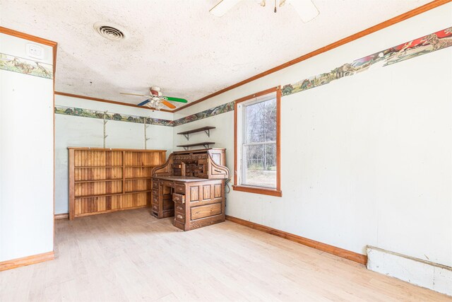 empty room with ceiling fan, light wood-type flooring, ornamental molding, baseboards, and a textured ceiling
