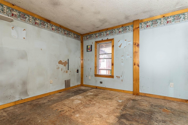 empty room with baseboards and a textured ceiling
