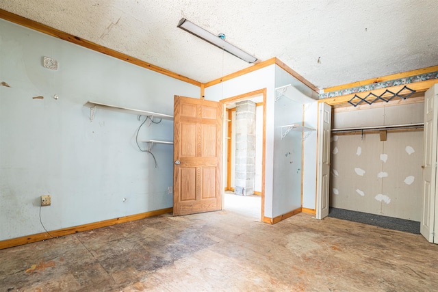unfurnished bedroom featuring ornamental molding, baseboards, and a textured ceiling