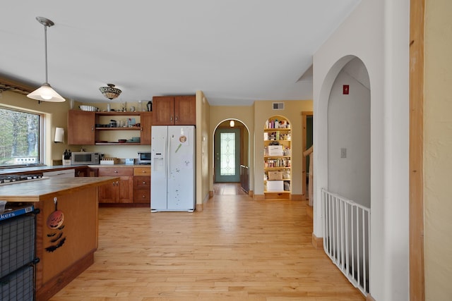 153 Wood Rd, Middlesex, VT 05682 - kitchen with white appliances, open shelves, arched walkways, and brown cabinetry