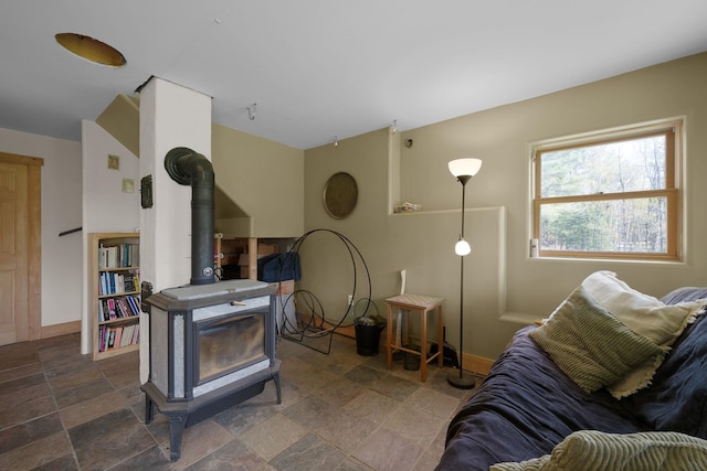 153 Wood Rd, Middlesex, VT 05682 - living area with a wood stove, stone finish flooring, and baseboards