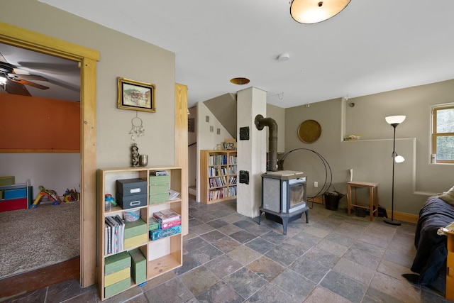 153 Wood Rd, Middlesex, VT 05682 - living area featuring a wood stove, stone tile flooring, ceiling fan, and baseboards