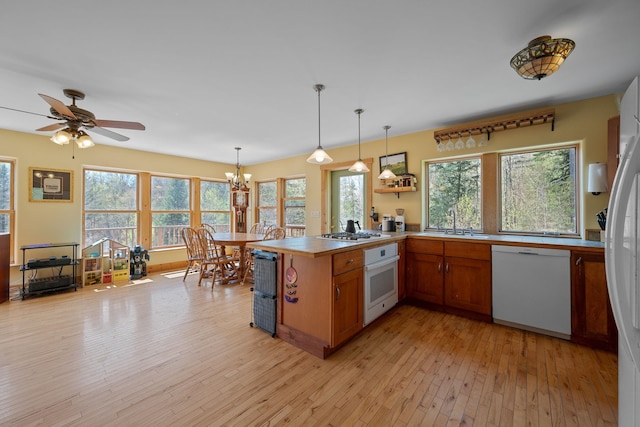 153 Wood Rd, Middlesex, VT 05682 - kitchen featuring white appliances, a peninsula, brown cabinets, and healthy amount of natural light