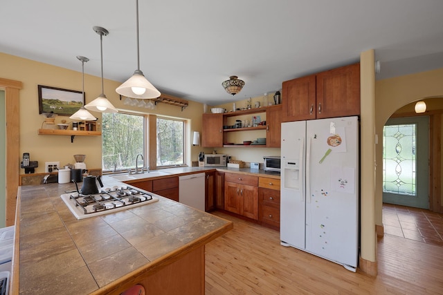 153 Wood Rd, Middlesex, VT 05682 - kitchen featuring white appliances, open shelves, a sink, arched walkways, and pendant lighting