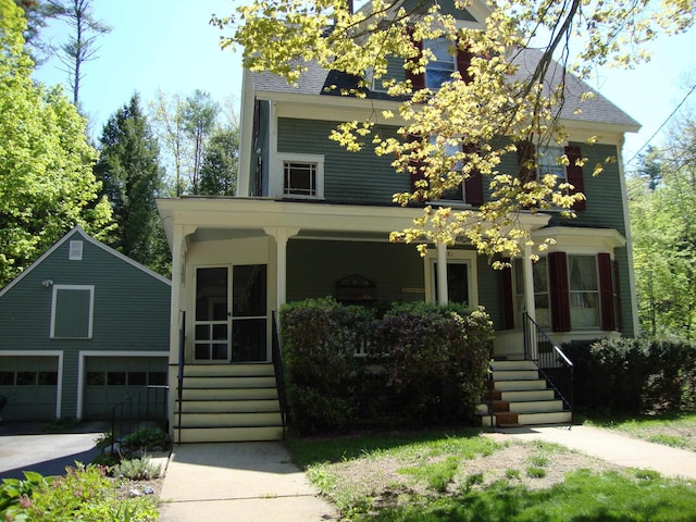 view of front facade with a porch, an outbuilding, and a garage