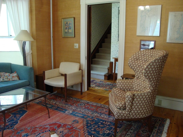 living area featuring wood-type flooring and stairs