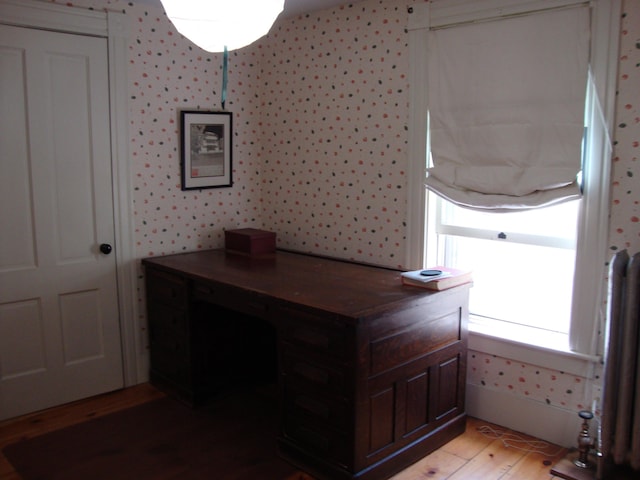 office space featuring light wood-style flooring and wallpapered walls