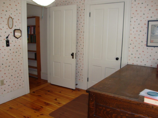 office featuring wallpapered walls and hardwood / wood-style floors