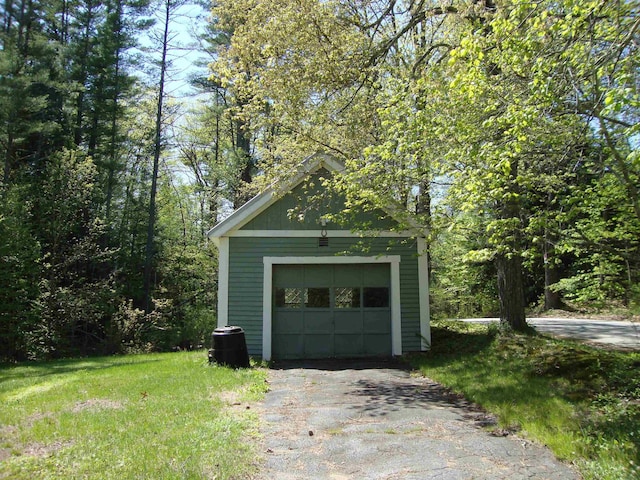 garage featuring asphalt driveway and central AC unit
