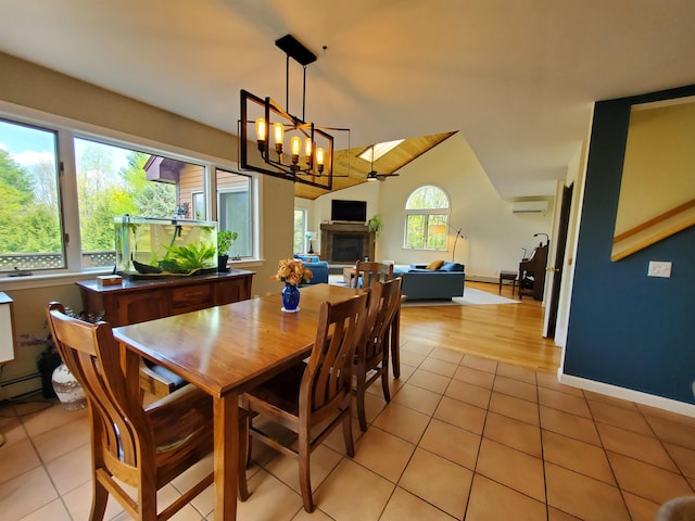 644 Methodist Hill Rd, Enfield, NH 03748 - dining space featuring light tile patterned floors, a chandelier, a fireplace, and lofted ceiling