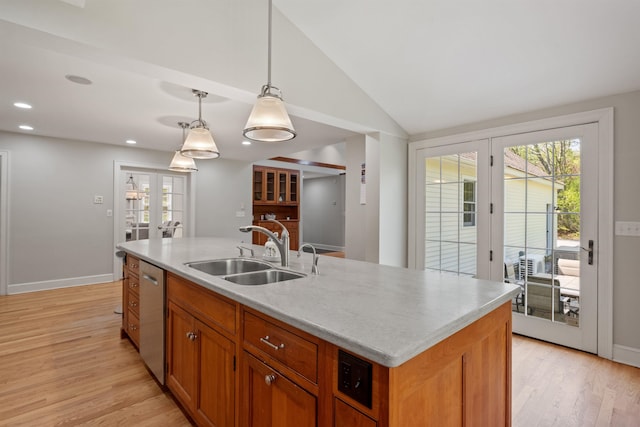 kitchen with a sink, french doors, stainless steel dishwasher, light wood-type flooring, and light countertops