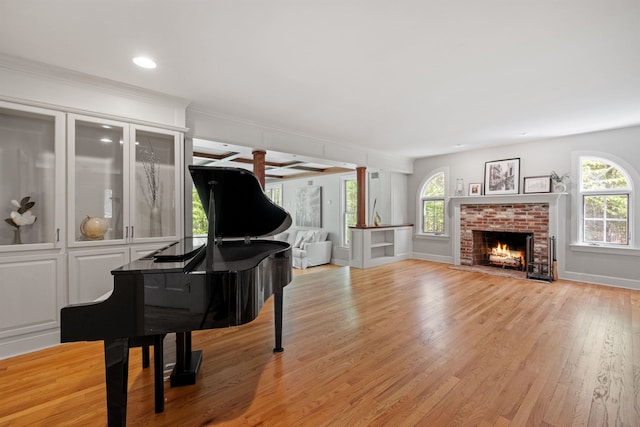 living area featuring light wood-style floors, baseboards, a fireplace, and recessed lighting