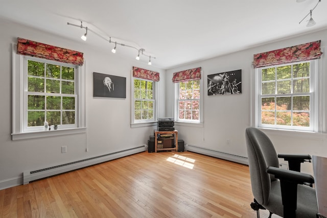 home office featuring a baseboard radiator, plenty of natural light, and light wood finished floors