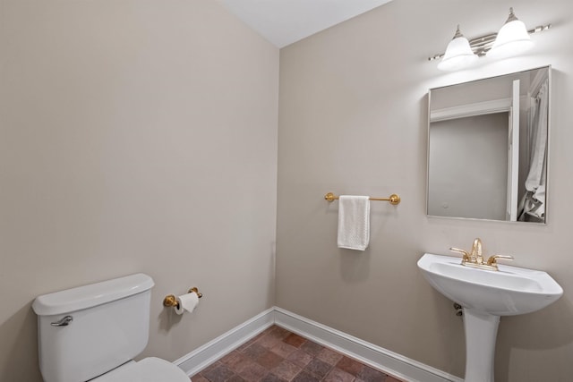 bathroom with baseboards and toilet