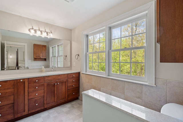 bathroom with tile walls, vanity, and a wainscoted wall