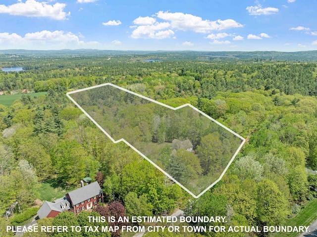 aerial view of property and surrounding area with a heavily wooded area and property parcel outlined