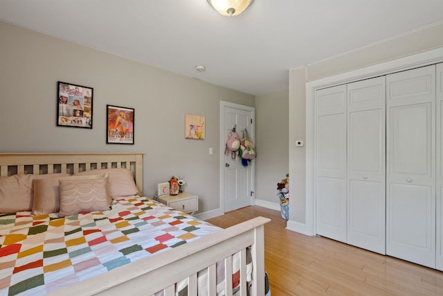 bedroom featuring light wood-style floors, a closet, and baseboards