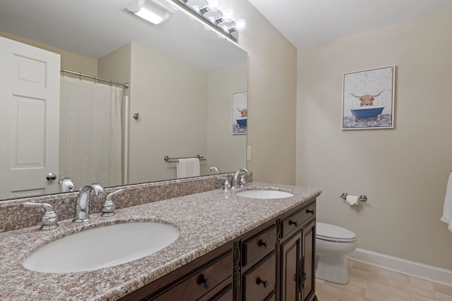 full bath featuring baseboards, toilet, and double vanity