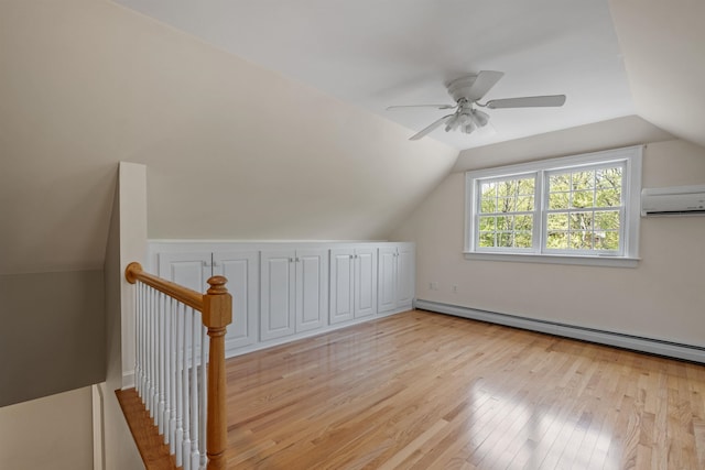 bonus room featuring light wood-style floors, lofted ceiling, a baseboard radiator, a ceiling fan, and a wall mounted air conditioner