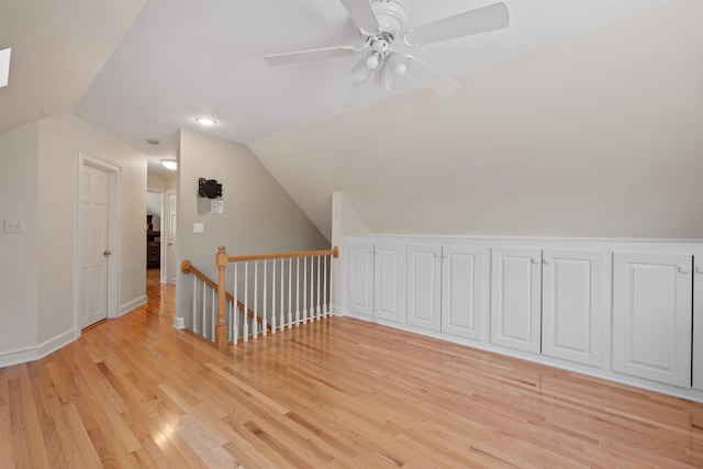 additional living space with lofted ceiling, light wood-style floors, a ceiling fan, and baseboards
