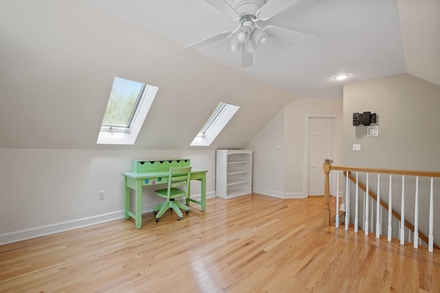 bonus room with a skylight, vaulted ceiling, wood finished floors, baseboards, and a ceiling fan